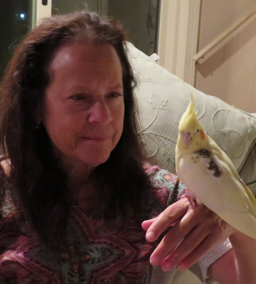 Donna Sue Rosenthal with a cockatiel resting on her hand